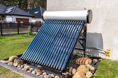 A modern solar pressure collector to heat domestic hot water, standing in front of the house on the lawn.