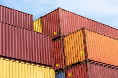 A stack of containers standing on top of each other in the loading yard by the wharf.