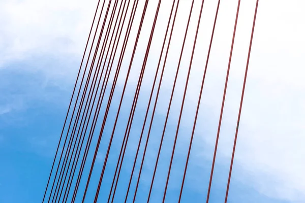 A large cable-stayed bridge on the German motorway over the river Rhine, against the blue sky, visible red steel ropes.