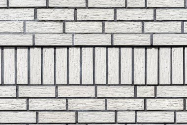 Binanın ön cephesinden yapılan arka plan beyaz tuğla, tuğlalar arasında büyük bir füg görünür.