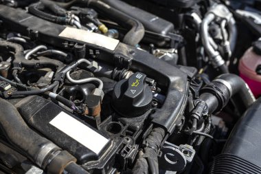 Bir dizel arabanın içindeki motor bölmesi, siyah ve motor parçaları halinde görünen kapalı yağ dolgusu..