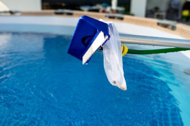 Bahçedeki ev havuzunu fırçayla temizlemek, ev havuzunun temizliği ve bakımı..