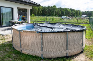 Genişleme havuzunun çapı 3.96 metre. Siyah kaplı. Arka bahçede, evin yanında..