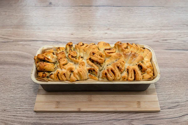 Homemade rectangular bread with garlic butter and herbs, in a baking tin.