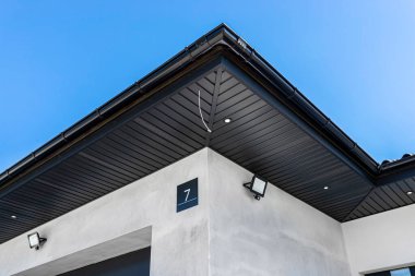 A modern graphite herringbone roof lining is attached to the trusses, visible turned on LED lights.