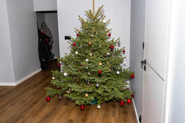 Ένα Έλατο Χριστουγεννιάτικο Δέντρο Διακοσμημένο Μπιχλιμπίδια Στέκεται Στην Αίθουσα Ενός — Φωτογραφία Αρχείου