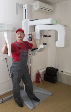 The technician repairs Digital Panoramic X-ray Sistem clipart