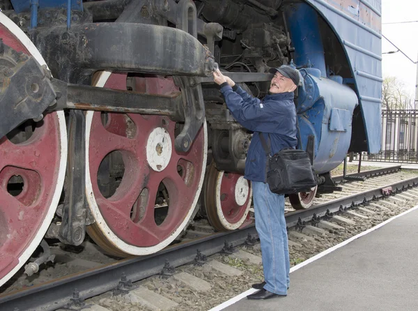 O maquinista repara uma locomotiva a vapor — Fotografia de Stock
