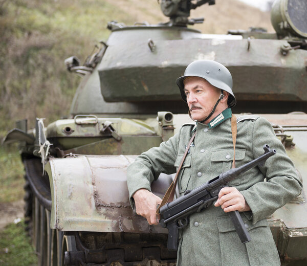 Человек в форме немецкий солдат Второй мировой войны с пистолетом Schmeisser
