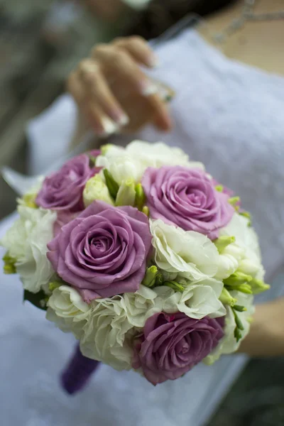 An elegant hand-tied bouquet of flowers in the hand of a bride. Shallow depth of field — Stock Photo, Image