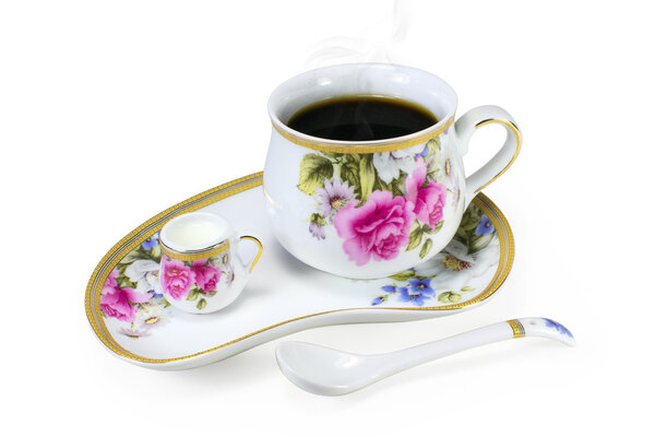 A set of porcelain cups with steaming tea or coffee and cream