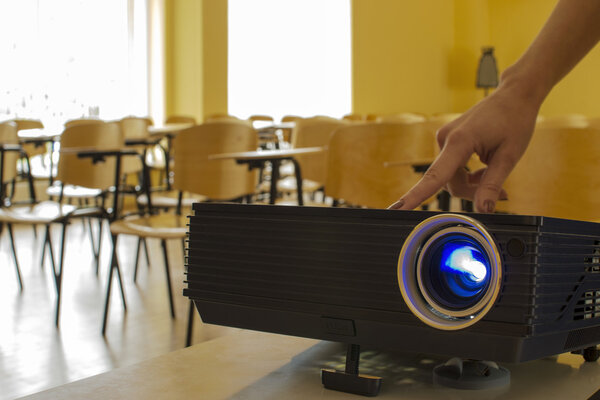 Digital projector being adjusted by a female hand