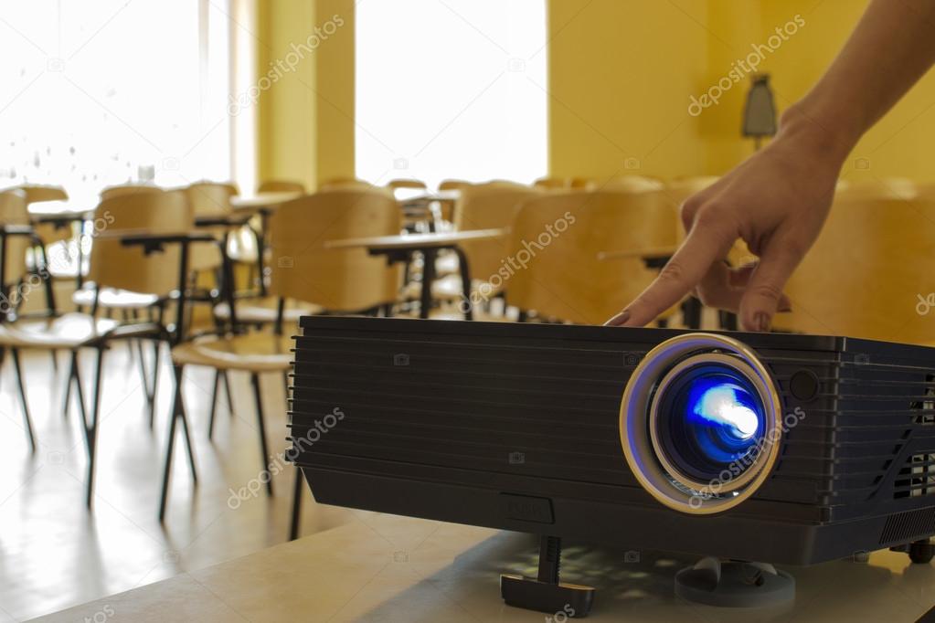 Digital projector being adjusted by a female hand