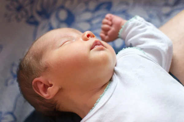Novorozeně (14 dní stará) spí na rodiče kolena — Stock fotografie
