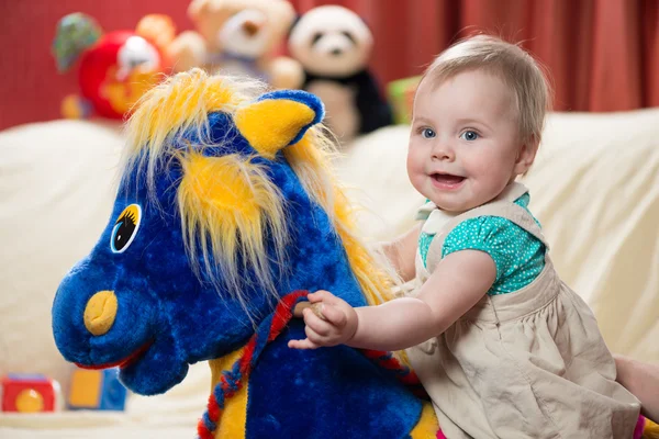 Baby on a rocking horse — Stock Photo, Image