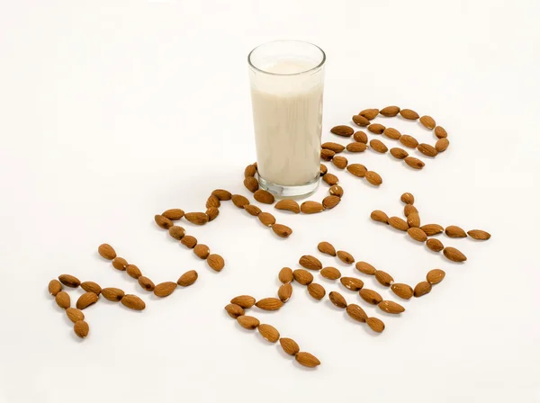 Almond milk and several almonds on a white background — Stock Photo, Image