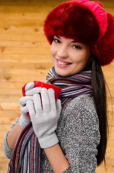 Beautiful girl drinking a hot beverage. — Stock Photo, Image