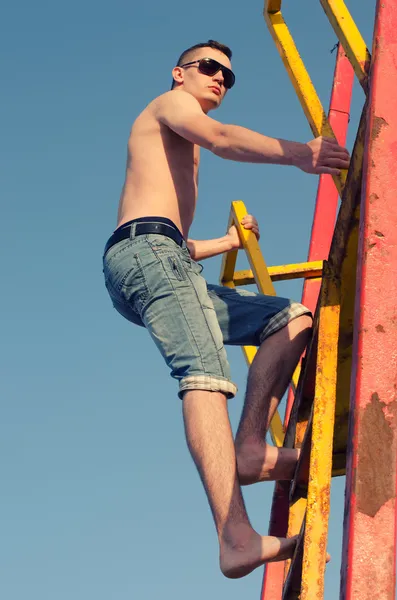 Young man climbing stairs to the sky