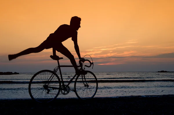 Een fiets bij de zonsopgang op het strand — Stockfoto