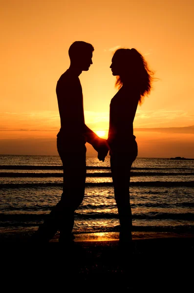 Paar genieten van hun tijd bij de zonsopgang op het strand — Stockfoto