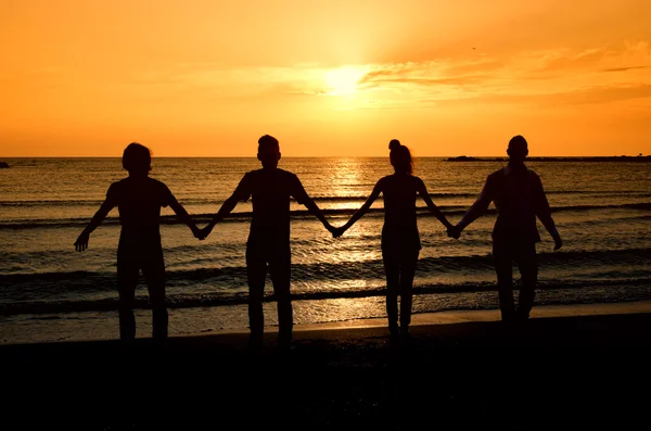 Group of happy parting on the beach at sunrise — Stock Photo, Image