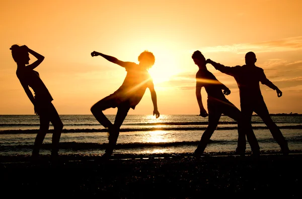 Boldog búcsú a tengerparton a napkelte csoportja — Stock Fotó