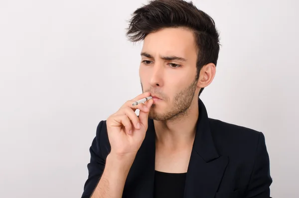 Молодой красивый бизнесмен курит — стоковое фото