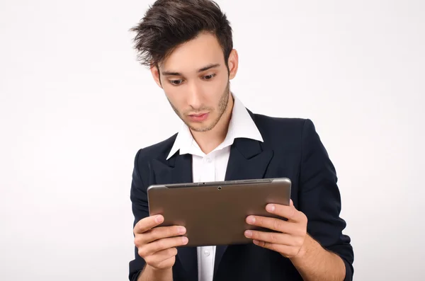 Jovem belo empresário trabalhando em um tablet — Fotografia de Stock