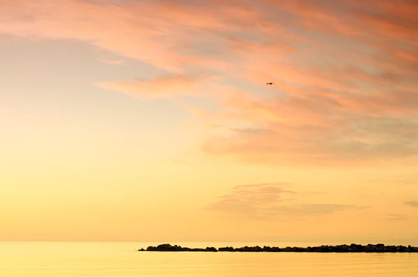 Bewolkte hemel bij zonsopgang boven de zee — Stockfoto