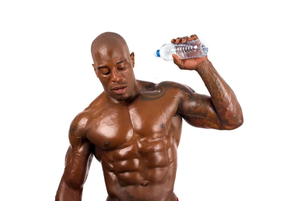 Construtor de corpo preto derramando água fria sobre si mesmo para esfriar depois de um treino duro. Homem forte com músculos perfeitos. Isolado sobre fundo branco . — Fotografia de Stock