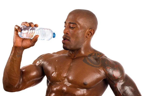 Svart bodybuilder hälla kallt vatten på sig att svalna efter ett hårt träningspass. stark man med perfekt muskler. isolerad på vit bakgrund. — Stockfoto