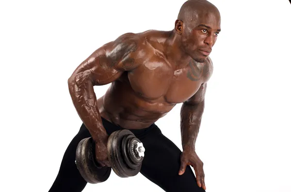 siyah vücut geliştirmeci dumbbells ile eğitim. mükemmel abs, omuzlar, pazı, triceps ve göğüs olan güçlü bir adam. Beyaz arka plan üzerinde izole