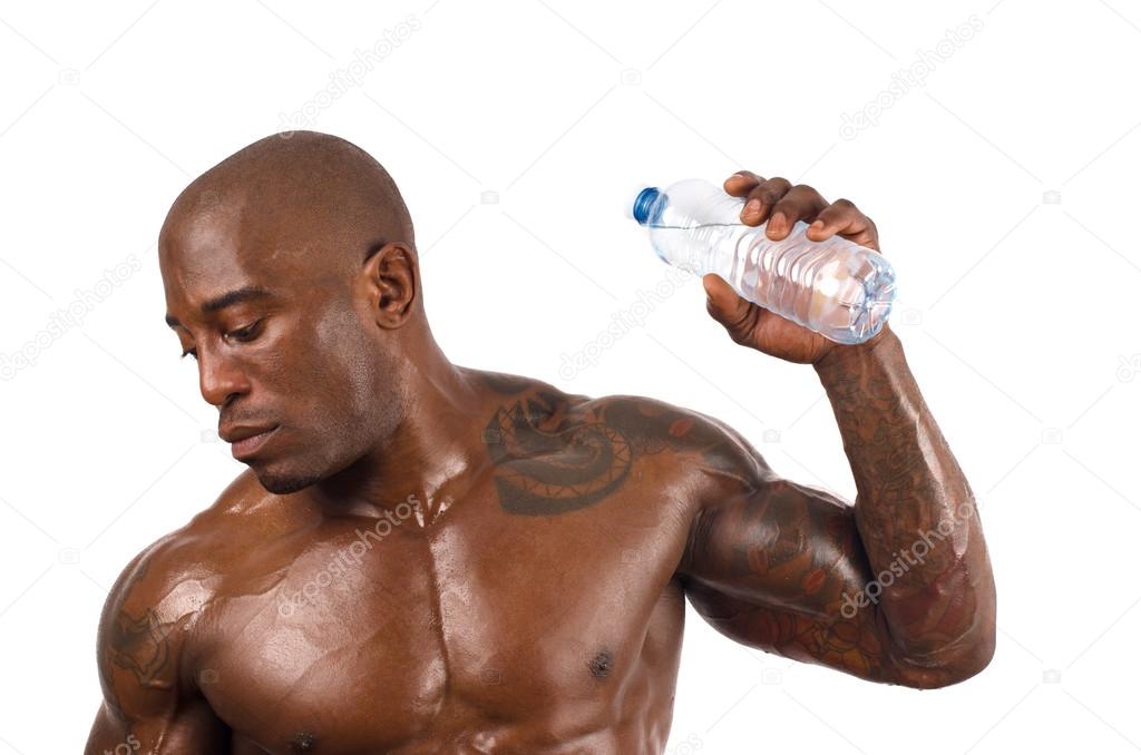 Black bodybuilder pouring cold water on himself to cool down after a hard workout. Strong man with perfect muscles. Isolated on white background.