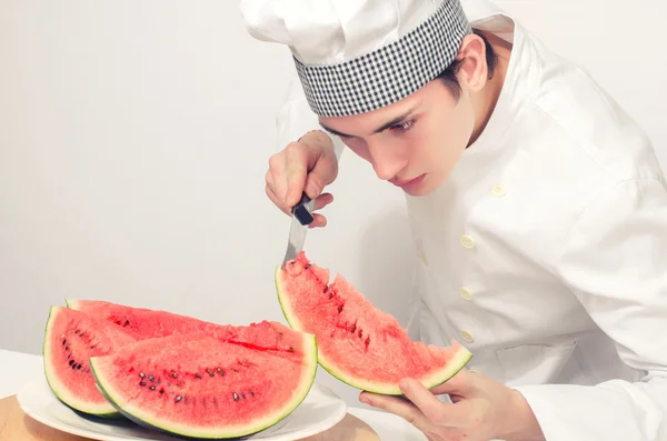 Chef coupant un melon vert en tranches parfaites — Photo