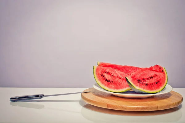 Fatias de um melão verde em uma mesa e uma grande faca — Fotografia de Stock