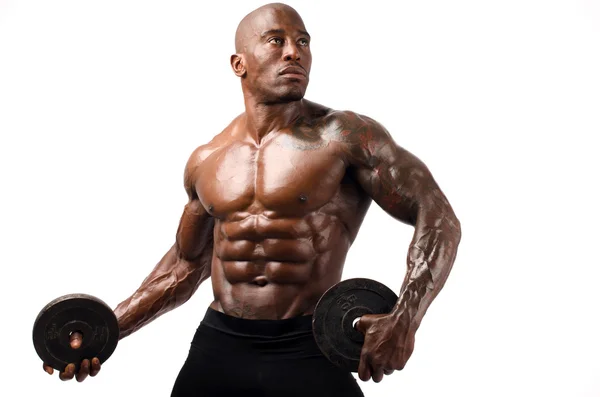 Black bodybuilder posing with round discs. Strong man with perfect abs, shoulders,biceps, triceps and chest. Isolated on white background — Stock Photo, Image