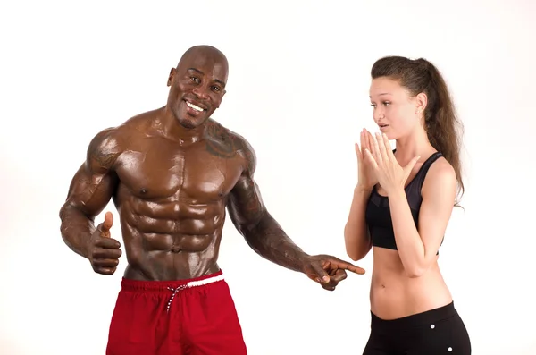 Beautiful woman impressed by the muscles of a bodybuilder — Stock Photo, Image