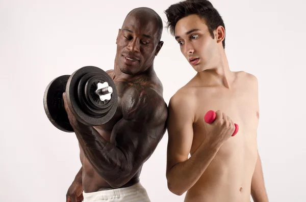 Two man, black and white, bodybuilder and a slim guy, comparing themselves — Stock Photo, Image