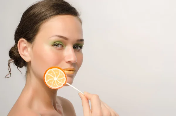 Beautiful woman posing with a sweet lollipop, colored candy — Stock Photo, Image