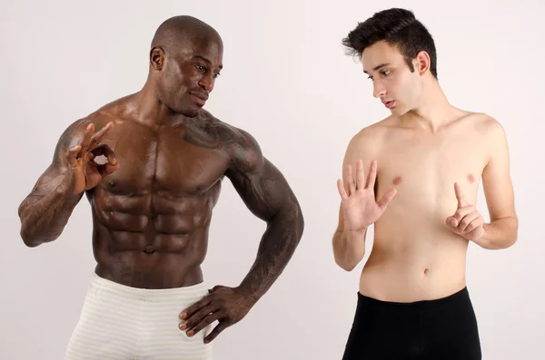 Two man, black and white, bodybuilder and a slim guy, comparing themselves, six pack abs to zero abs — Stock Photo, Image