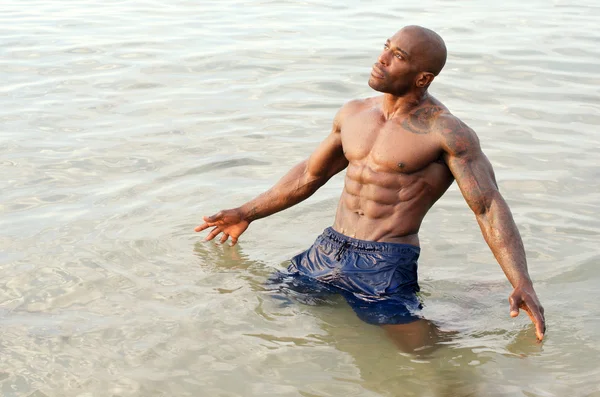 Culturista negro relajándose en el agua después de un duro entrenamiento durante unas vacaciones de verano —  Fotos de Stock