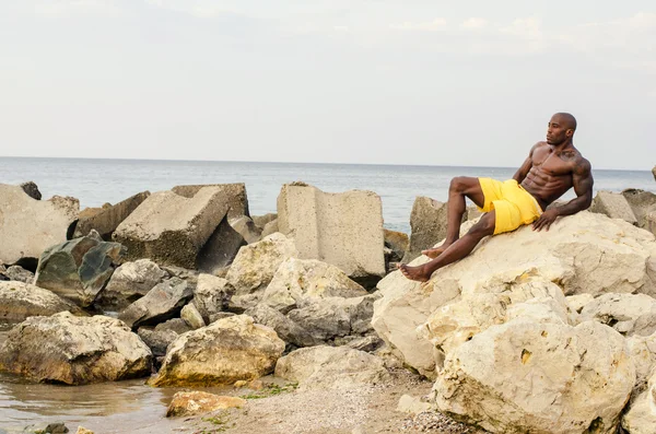 Черный культурист расслабляется в воде после тяжелой тренировки во время летних каникул — стоковое фото