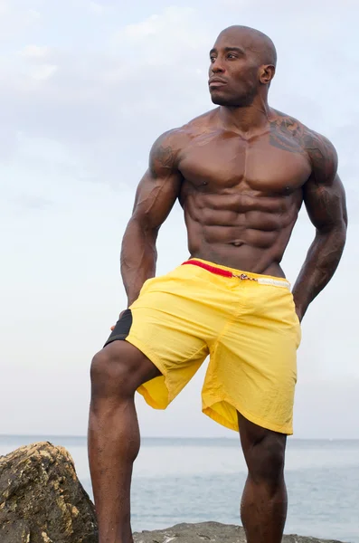 Black bodybuilder relaxing in the water after a hard workout during a summer vacation — Stock Photo, Image