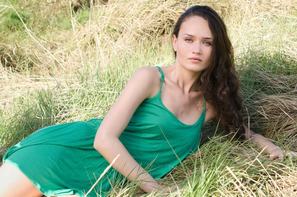 美丽的女人放松在草丛中的性质 — 图库照片