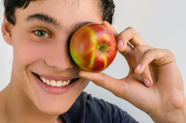 Hermoso hombre sonriendo y sosteniendo una manzana roja promoviendo una vida saludable —  Fotos de Stock