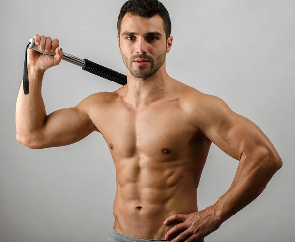 Bodybuilder utbildning med bendy bar. stark man med perfekta abs, Pécs axlar, biceps, triceps. isolerad på vit bakgrund — Stockfoto