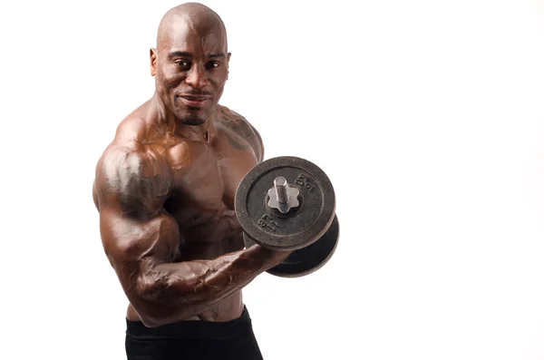 Siyah vücut dumbbell ile eğitim. mükemmel abs, omuzlar, pazı, triceps ve göğüs olan güçlü bir adam. Beyaz arka plan üzerinde izole — Stok fotoğraf