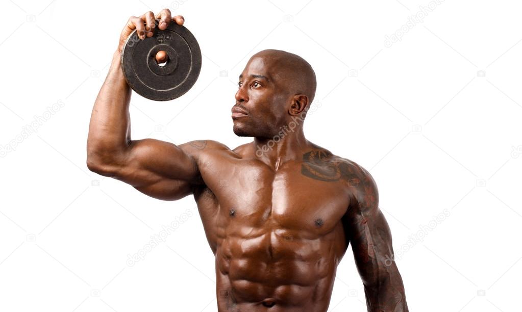 Black bodybuilder posing with round discs. Strong man with perfect abs, shoulders,biceps, triceps and chest. Isolated on white background