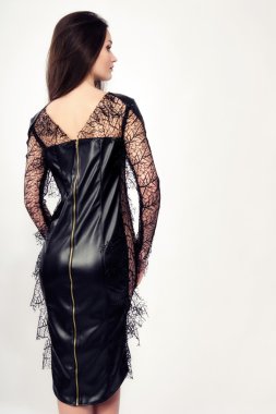 Kız poz moda seksi popo siyah deri üzerinde dar elbise. dantel kolları arkadan poz siyah elbise giyen güzel esmer kadın