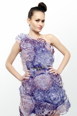 dantel çiçekler mor bir elbise giymiş ve onun kalçalarına ellerini tutan güzel bir kadın. kız moda poz
